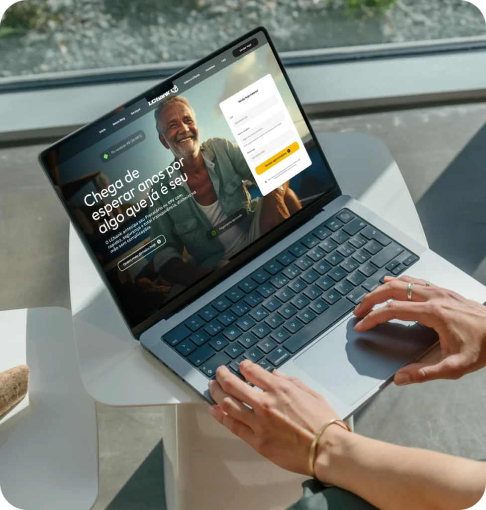 Laptop aberto exibindo o site do LCbank com foco em "Chega de esperar por algo que já é seu